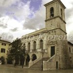 Costruito nel secolo XIII,fu restaurato in varie epoche,a causa dei frequenti terremoti.
Del secolo XIII rimane il portico con colonne basse e tozze,dove un tempo vi era l'archivio notarile,la Grascia e la Gabella di cui resta un'interessante tariffa daziaria del secolo XVII su una parete.
La parte superiore del palazzo acquistò il volto attuale dopo il terremoto del 1859.
La torre campanaria è del 1713,la porta principale della seconda metà del '500 opera di Antonio Marinucci,costruttore nursino che intervenne anche nei lavori della Castellina